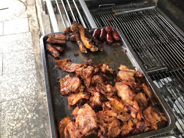 「バーイサイッチュルーク」の豚肉を炭火で焼く